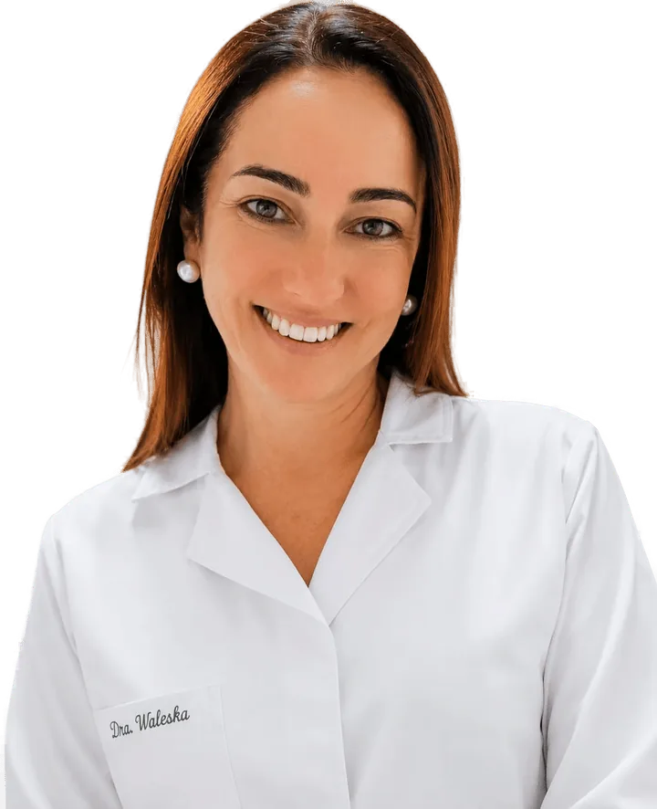 Dra. Waleska Cid Silva sorrindo, de jaleco branco bordado com seu nome
